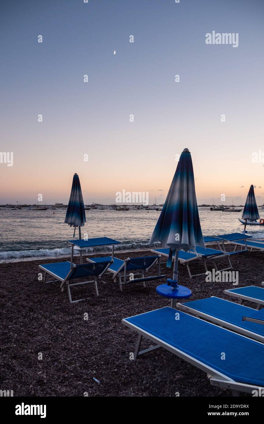 Plage de Positano dans la soirée à Dusk au clair de lune Avec parasols et chaises de plage Banque D'Images