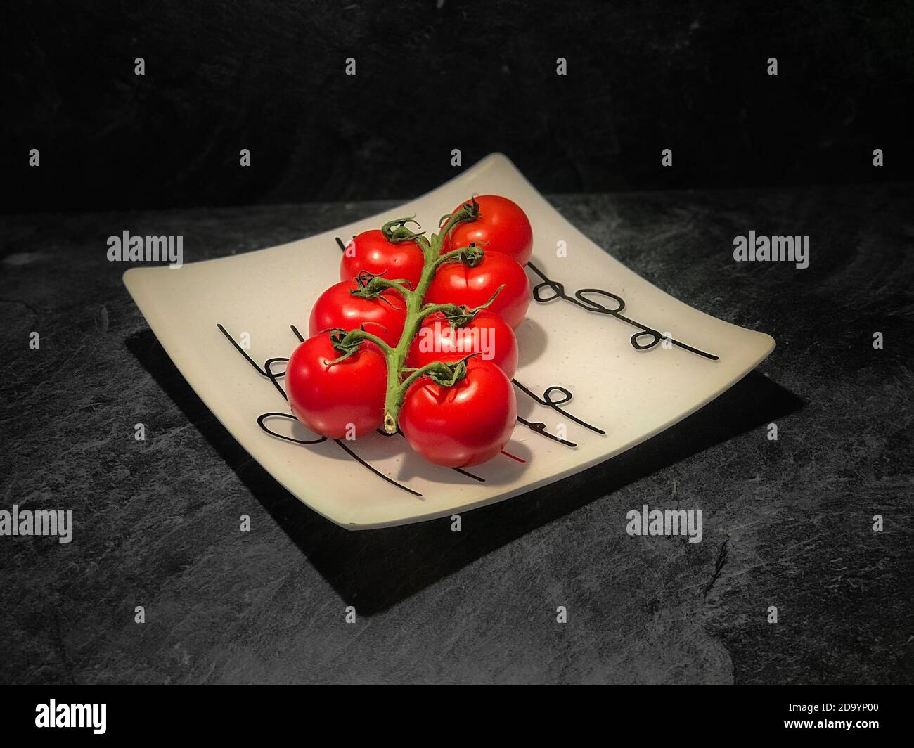 Sept tomates sur un plat en verre Banque D'Images