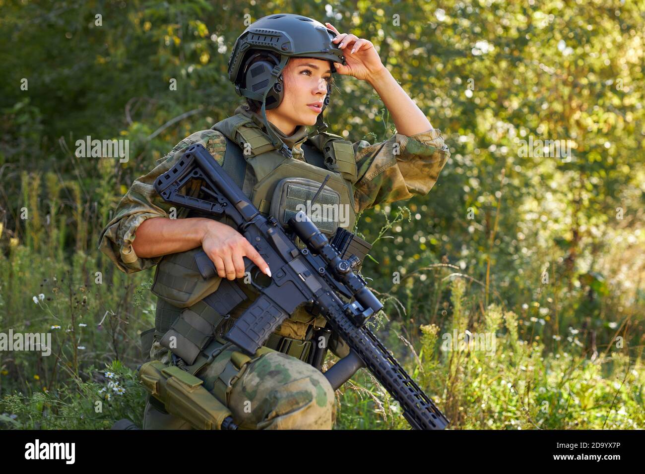 militaire courageuse et puissante, avec mitraillette à carabine debout dans la forêt, elle est prête à tirer à l'ennemi, tir à l'extérieur d'arme à feu Banque D'Images