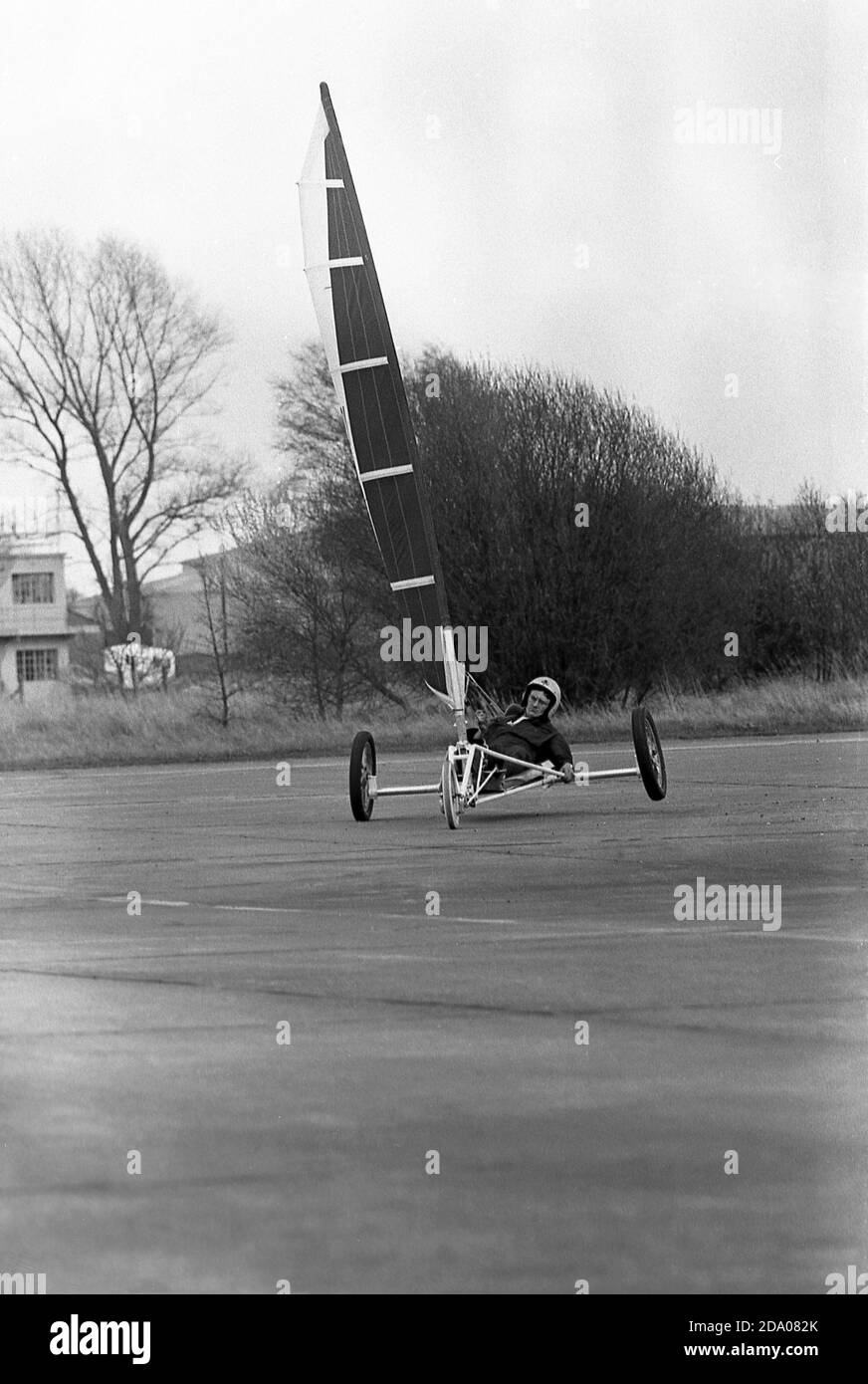 Années 1980, historique, un concurrent masculin participant à une compétition de char à voile, Angleterre, Royaume-Uni. Également connue sous le nom de voile terrestre, l'activité implique un véhicule à roues alimenté par le vent grâce à l'utilisation d'une voile. Banque D'Images
