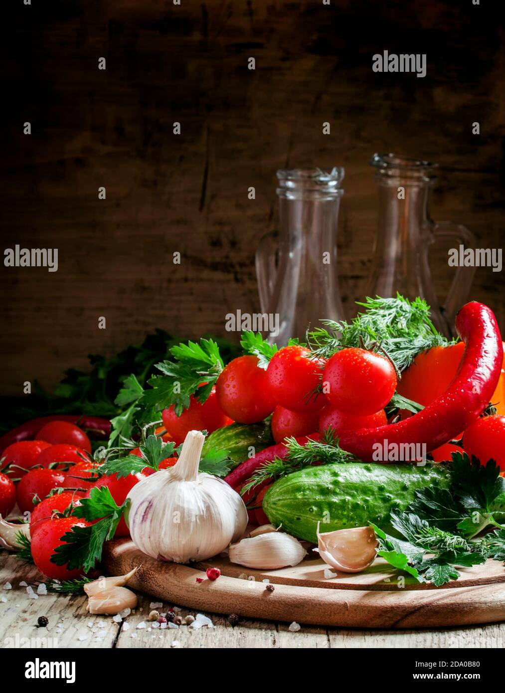Ail frais, tomates cerises, concombre, poivre chaud, persil, aneth sur une planche à découper en bois, légumes pour le régime méditerranéen, attention sélective Banque D'Images