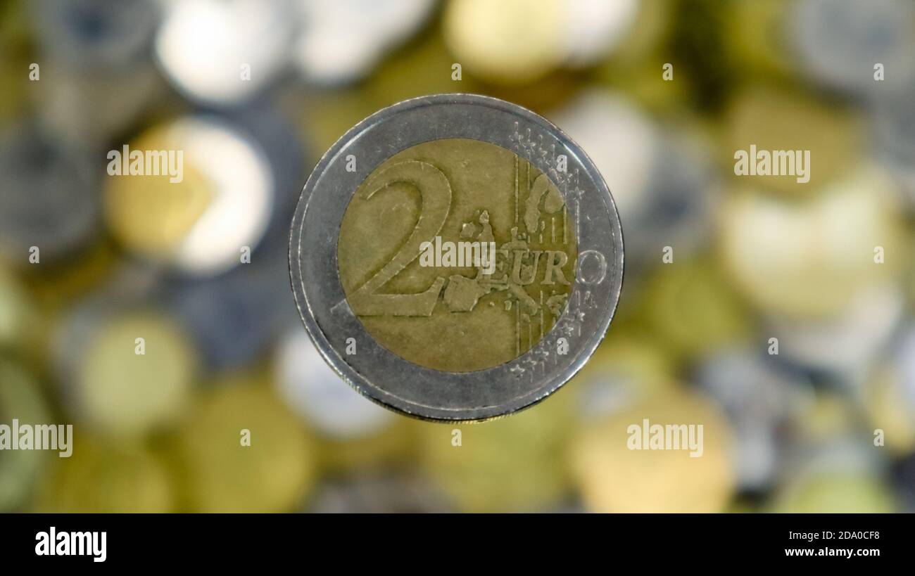 Un gros plan montre une pièce de 2 euros. C'est de l'argent. Symbole de devise de financement. Fond d'argent flou. Au verso, il y a une carte élargie de TH Banque D'Images