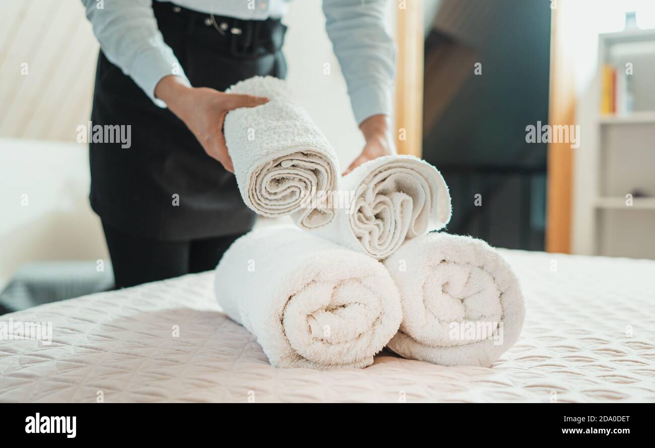 Un service de chambre. Changement des serviettes femme dans chambre d'hôtel. Banque D'Images