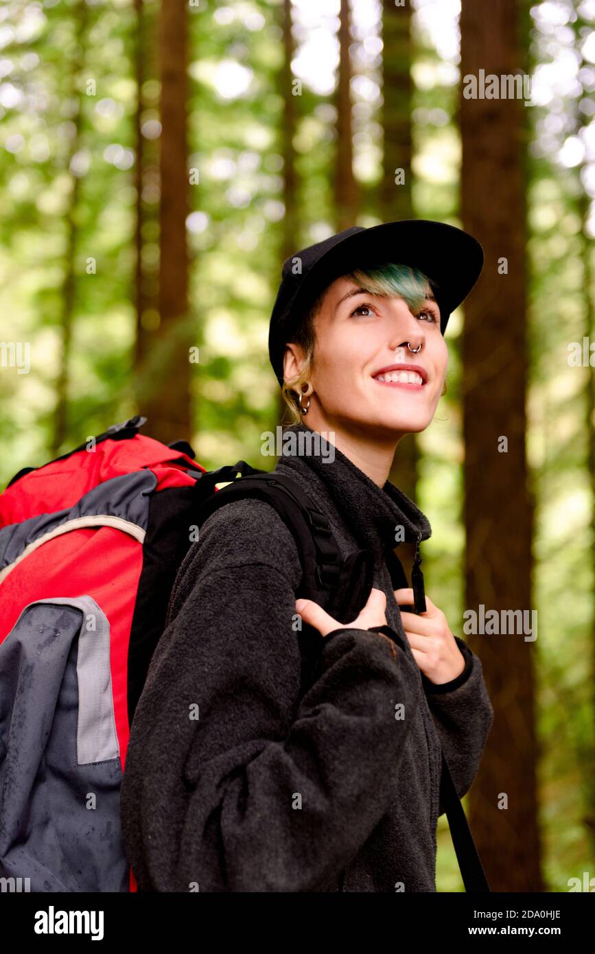 Content touriste femelle avec sac à dos debout dans les bois et appréciant Paysage incroyable de grands arbres dans le monument naturel de Monte Cabezon De séquoias Banque D'Images