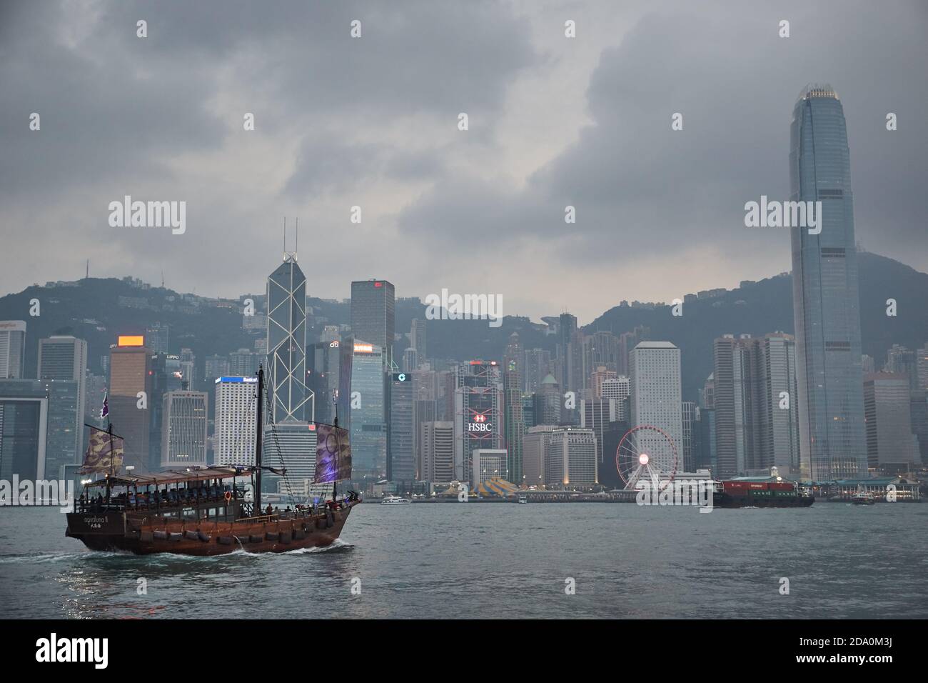 Hong Kong, Chine, avril 2018.Bateaux naviguant dans la baie de Kowloon avec les gratte-ciel de Hong Kong en arrière-plan, au coucher du soleil. Banque D'Images
