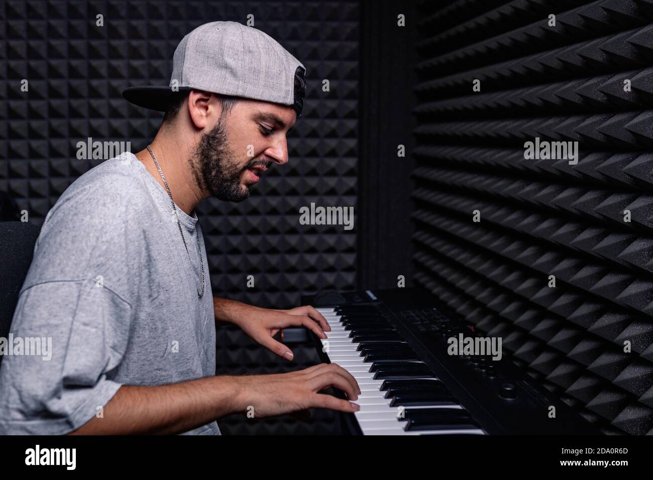 Vue latérale d'un musicien de sexe masculin qualifié jouant du piano  électrique chambre acoustique avec murs en mousse insonorisés Photo Stock -  Alamy