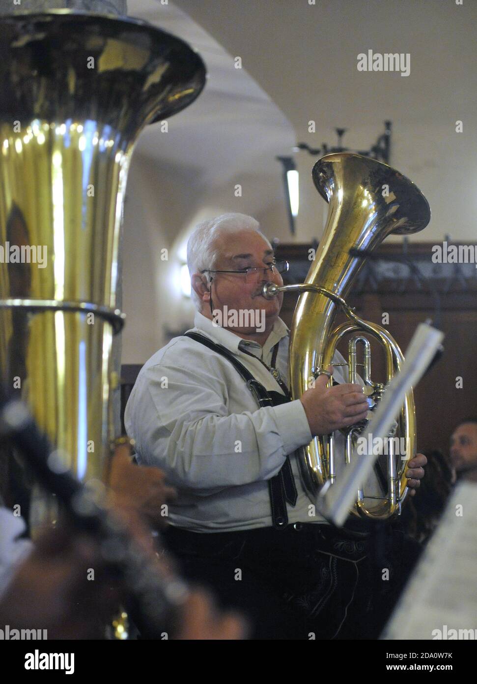 Un joueur de tuba habillé à Lederhosen dans un groupe traditionnel de cuivres bavarois joue dans le célèbre pub Hofbrahaus de Munich, en Allemagne. Banque D'Images