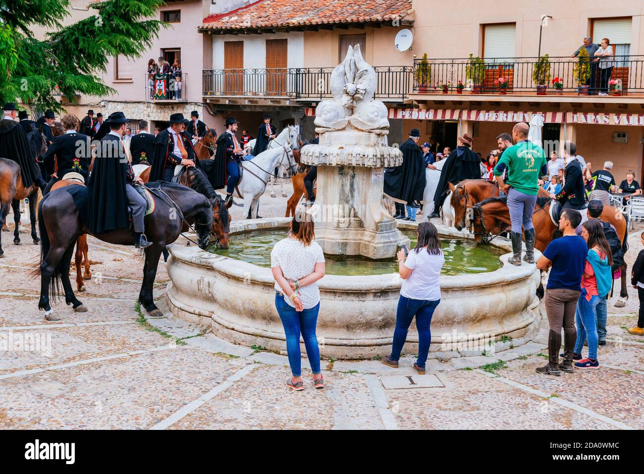 Les chevaux boivent de la fontaine de la Plaza de España. Fête 'la Caballada'. La Fraternité de la Sainte Trinité. Atienza, Guadalajara, Castilla la Ma Banque D'Images