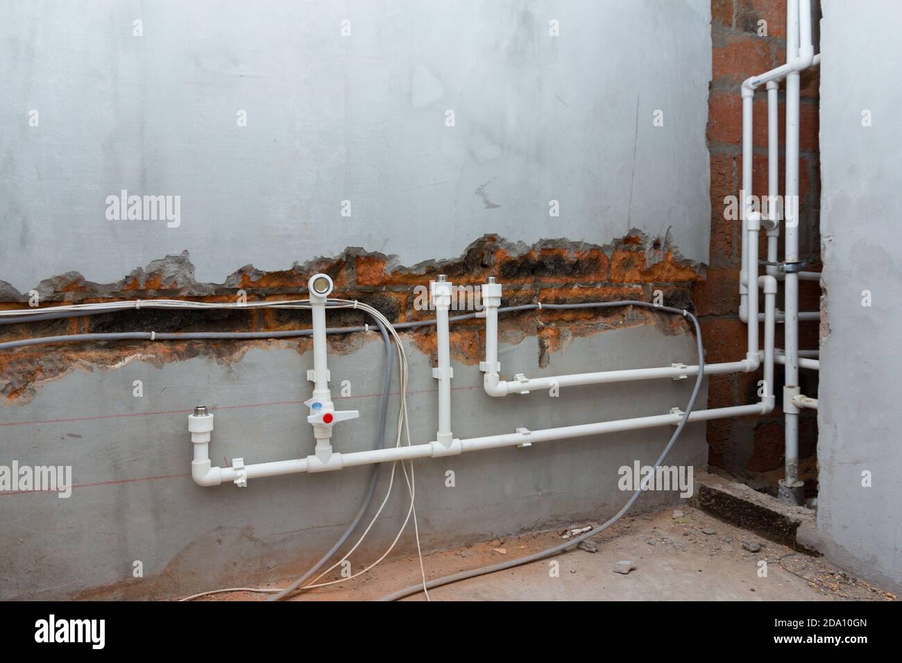 Installation du système d'alimentation en eau. Pose de tuyaux dans le mur.  Eau froide et chaude dans l'appartement Photo Stock - Alamy