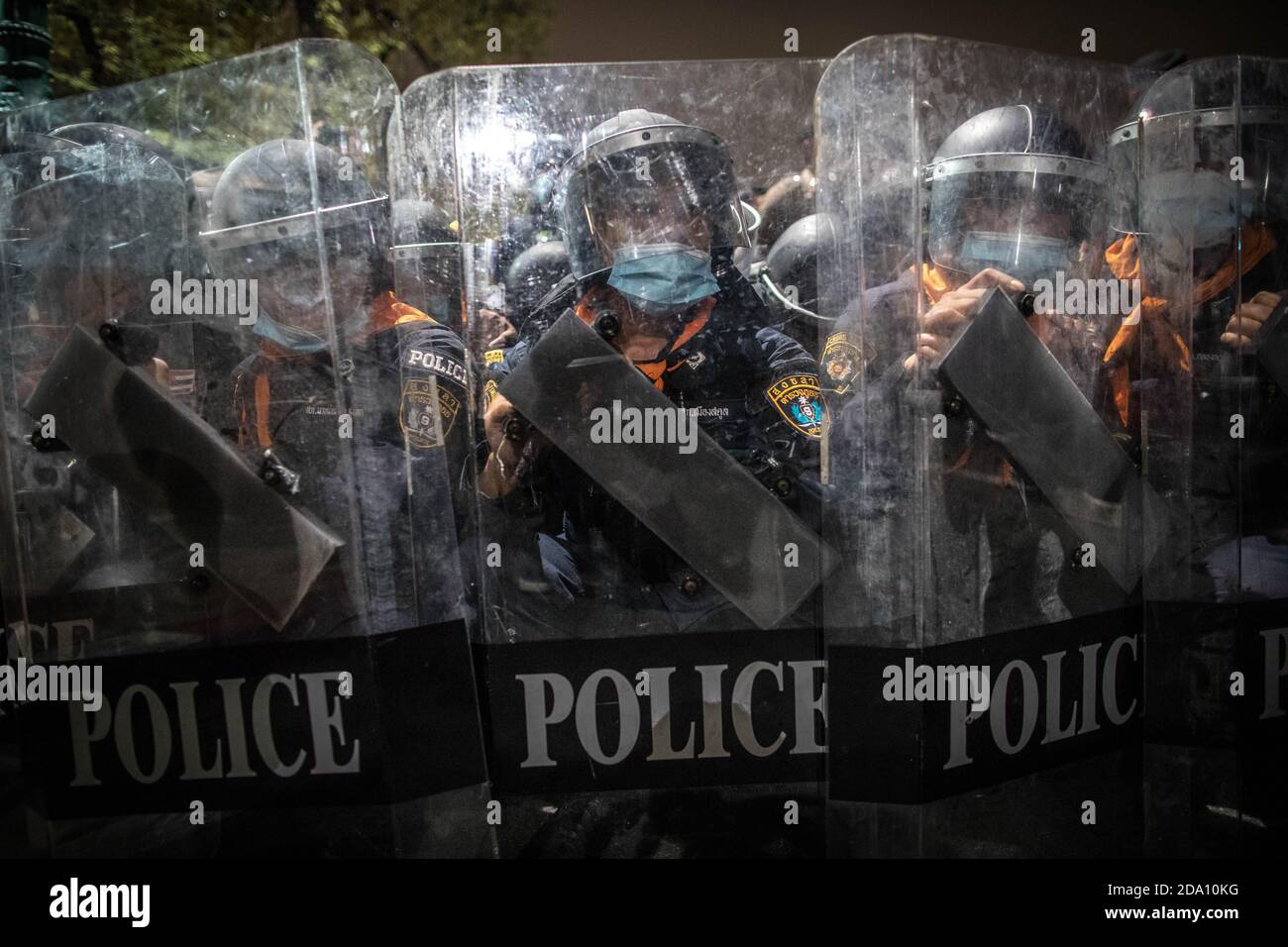 Bangkok, Thaïlande. 08 novembre 2020. Des policiers anti-émeutes vus derrière leurs boucliers lors d'une manifestation antigouvernementale dans la capitale thaïlandaise. Des manifestants pro-démocratie ont pris les rues du Monument de la démocratie pour marcher vers le Grand Palais pour livrer une lettre au roi de Thaïlande Maha Vajiralongkorn (Rama X), les manifestants ont été accueillis par la police thaïlandaise qui a utilisé des bus de la ville et des barbelés pour bloquer la route, Et des canons à eau pour disperser la foule à Sanam Luang en face du Grand Palais. Crédit : SOPA Images Limited/Alamy Live News Banque D'Images