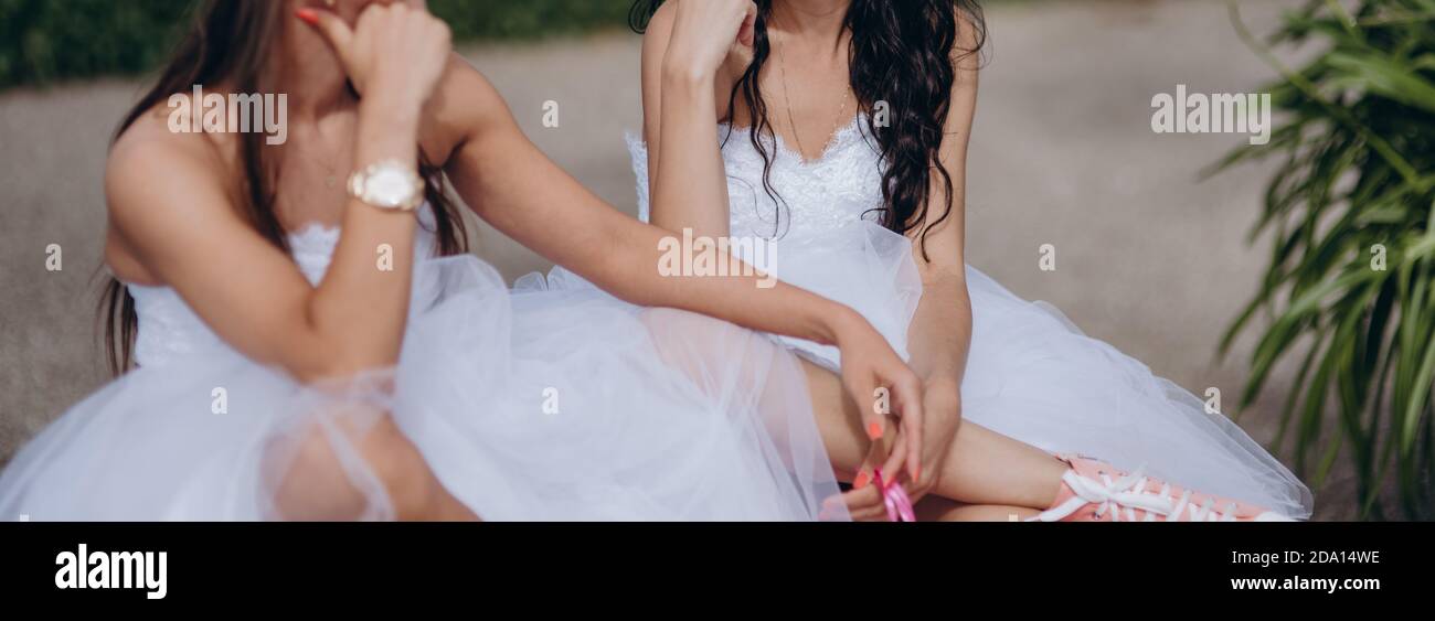 Newlyweds couple lesbien à leur heureux jour de mariage portant des robes blanches et tenant des bouquets. Concept d'égalité. Banque D'Images