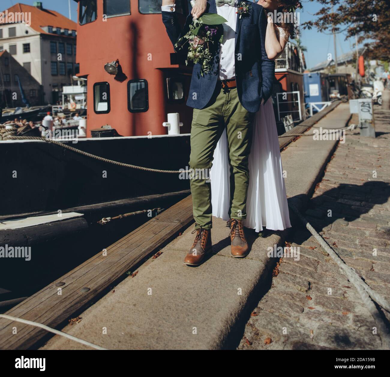 Couple de mariés se posant ensemble à côté de la Manche avec des navires à Copenhague. Banque D'Images Couple de mariés se posant ensemble à côté de la Manche avec des navires à Copenhague. Banque D'Images