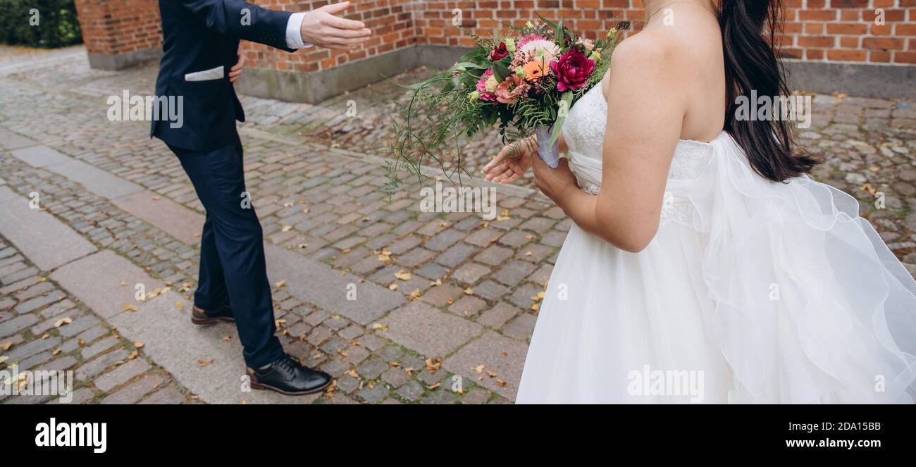 Marié donne une main à la mariée. Couple de mariée célébrant ensemble le joyeux jour de mariage. Banque D'Images Marié donne une main à la mariée. Couple de mariée célébrant ensemble le joyeux jour de mariage. Banque D'Images