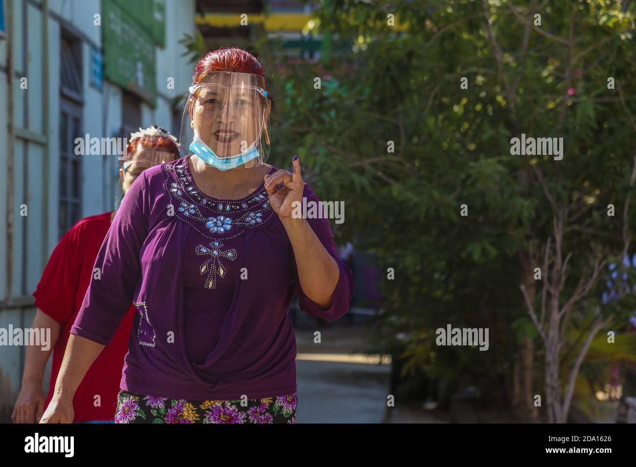 Mandalay, Myanmar. 08 novembre 2020. Une femme soulève le doigt appuyé devant le bureau de vote après qu’elle ait fini de voter.les citoyens du Myanmar ont voté lors de la deuxième élection démocratique depuis la fin du régime militaire, Aung San Suu Kyi étant prévu que la Ligue nationale pour la démocratie (NLD) remporte les élections. Crédit : SOPA Images Limited/Alamy Live News Banque D'Images