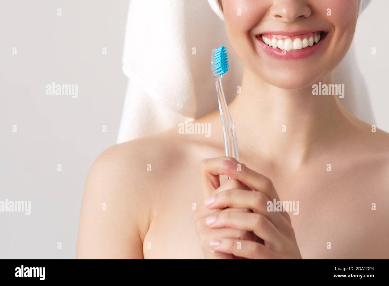 Femme souriante nettoyant ses dents avec une brosse à dents dans un concept d'hygiène dentaire. Isolé sur blanc Banque D'Images