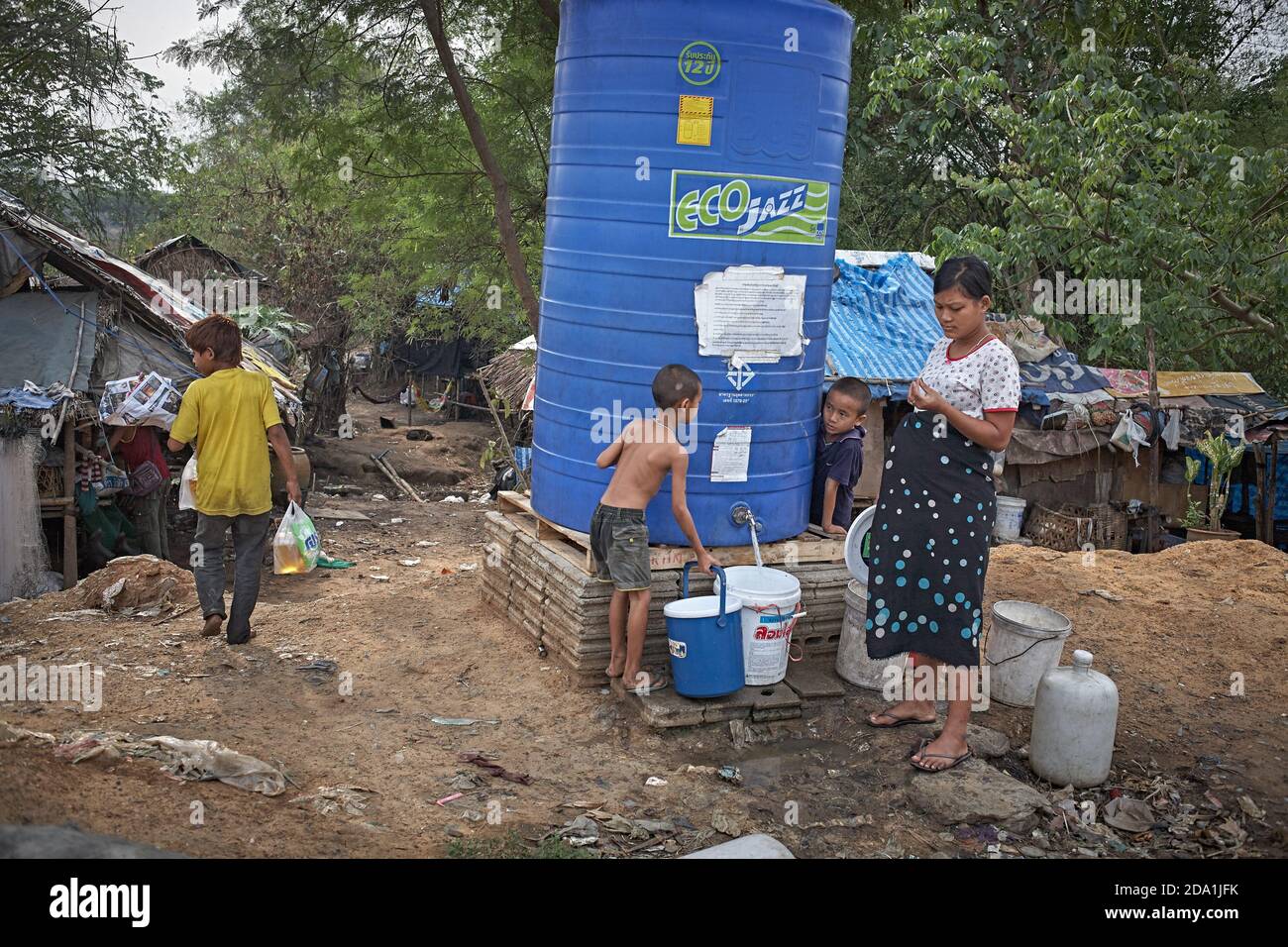 Mae SOT, Thaïlande. Avril 2012. Des réfugiés du Myanmar, dans un bidonville au niveau de la décharge à ordures, ramassant de l'eau dans un réservoir. Banque D'Images