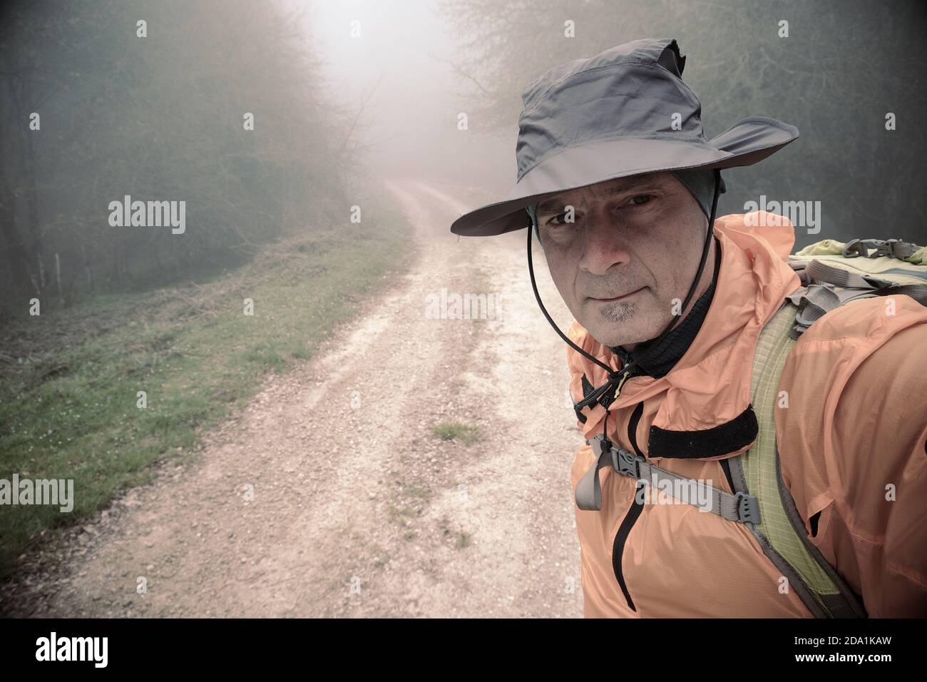 Randonneur avec chapeau prenant un selfie le long d'un sentier brumeux dans le parc Nebrodi, Sicile Banque D'Images
