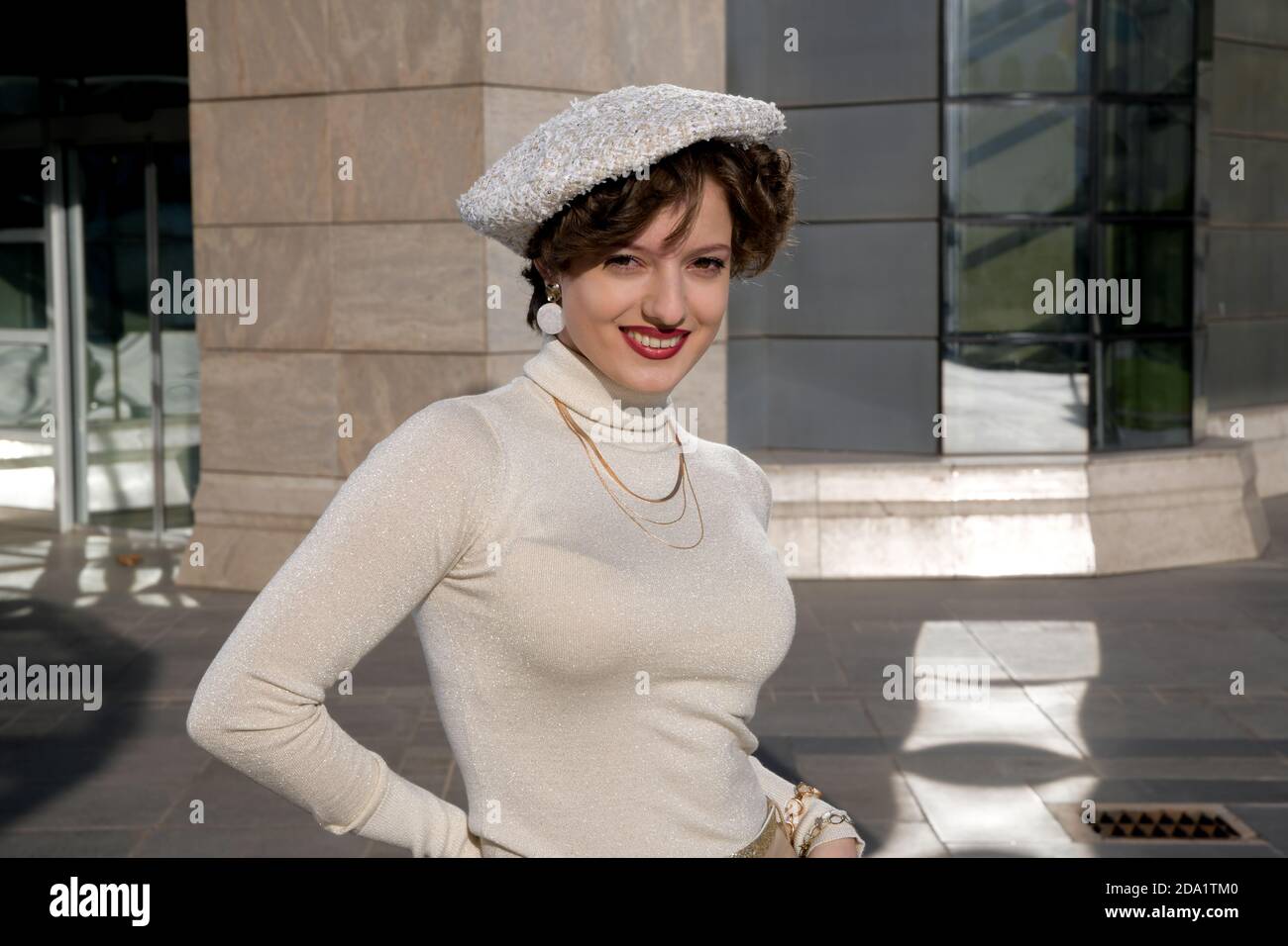 Portrait de mode en plein air de la jeune belle fille à la mode avec béret, posant dans la ville européenne, près de l'architecture moderne. Concept de mode d'automne Banque D'Images