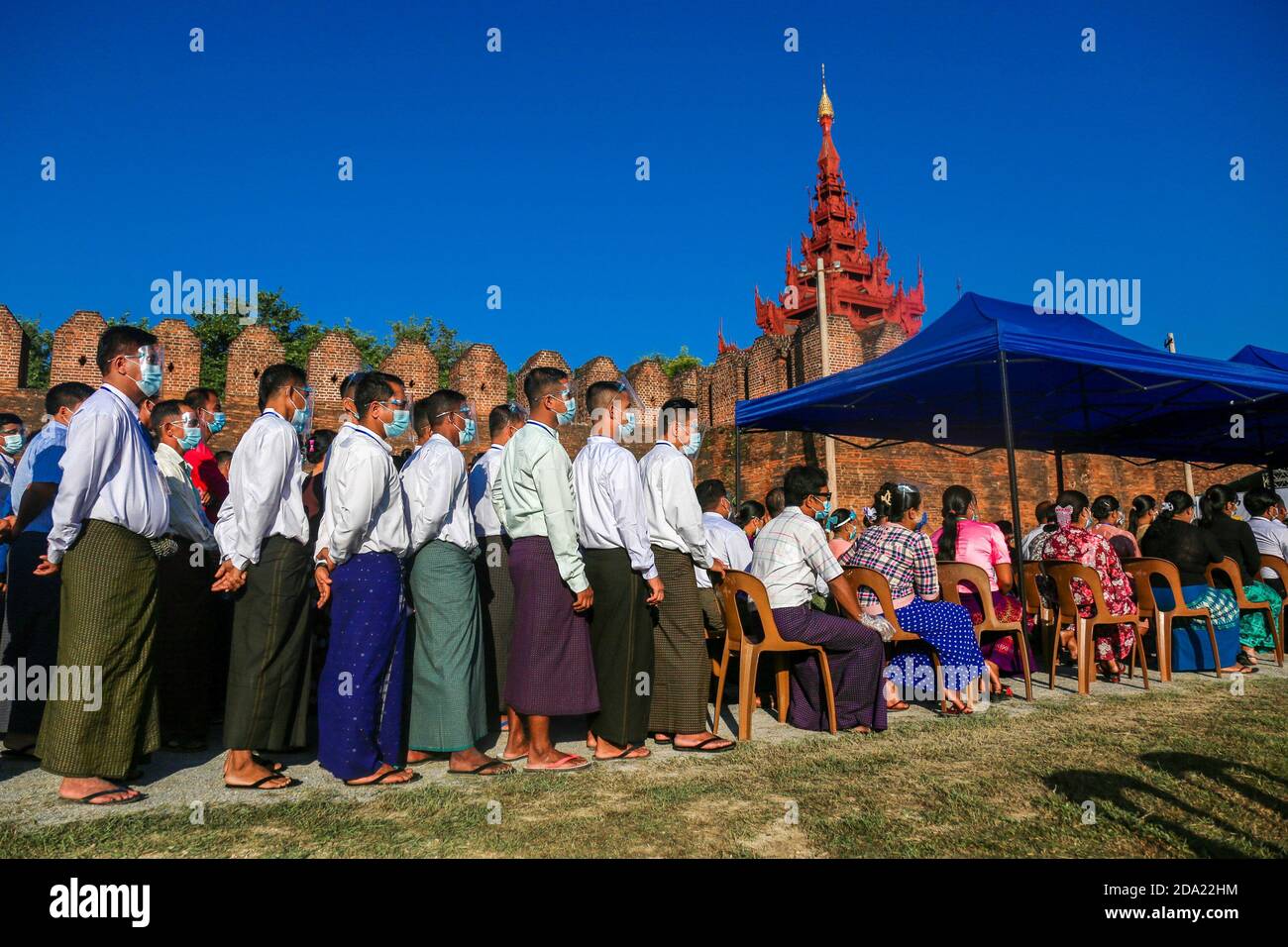Les membres de la famille militaire vêtu de masques faciaux attendent devant le palais pour voter.les citoyens du Myanmar ont voté lors de la deuxième élection démocratique depuis la fin du régime militaire, la Ligue nationale pour la démocratie (NLD) Aung San Suu Kyi s'attendait à remporter l'élection. Banque D'Images