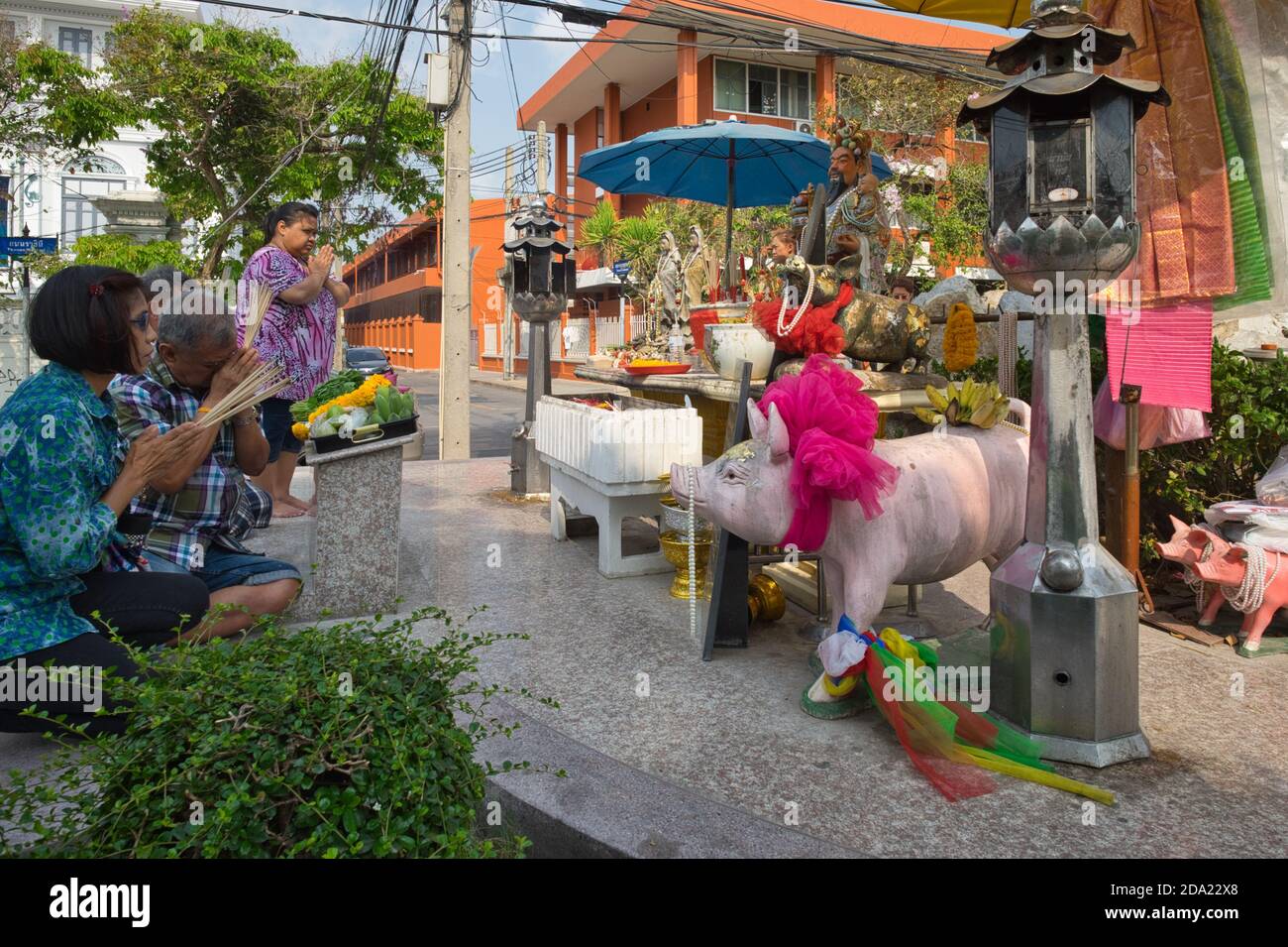 Les adorateurs prient devant les personnages porcins, au sanctuaire de cochons ou au Mémorial de Sahachat (Sahachart), sur la route Ratchini, à côté de Klong Lod, Bangkok, en Thaïlande Banque D'Images