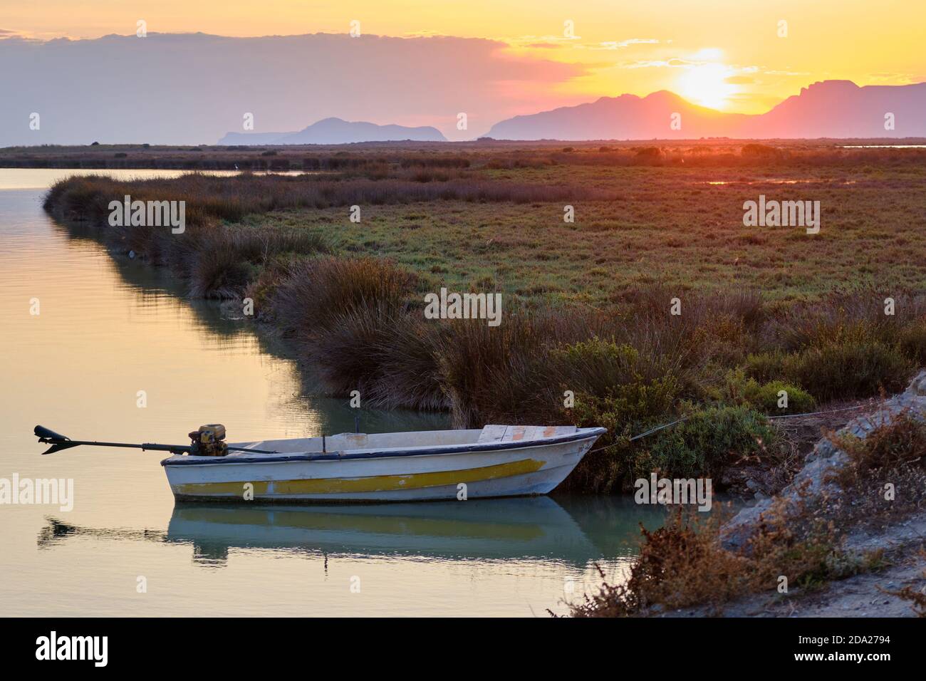 Bateau avec un moteur électrique est amarré à la rive. Coucher de soleil en bord de mer avec bateau Banque D'Images