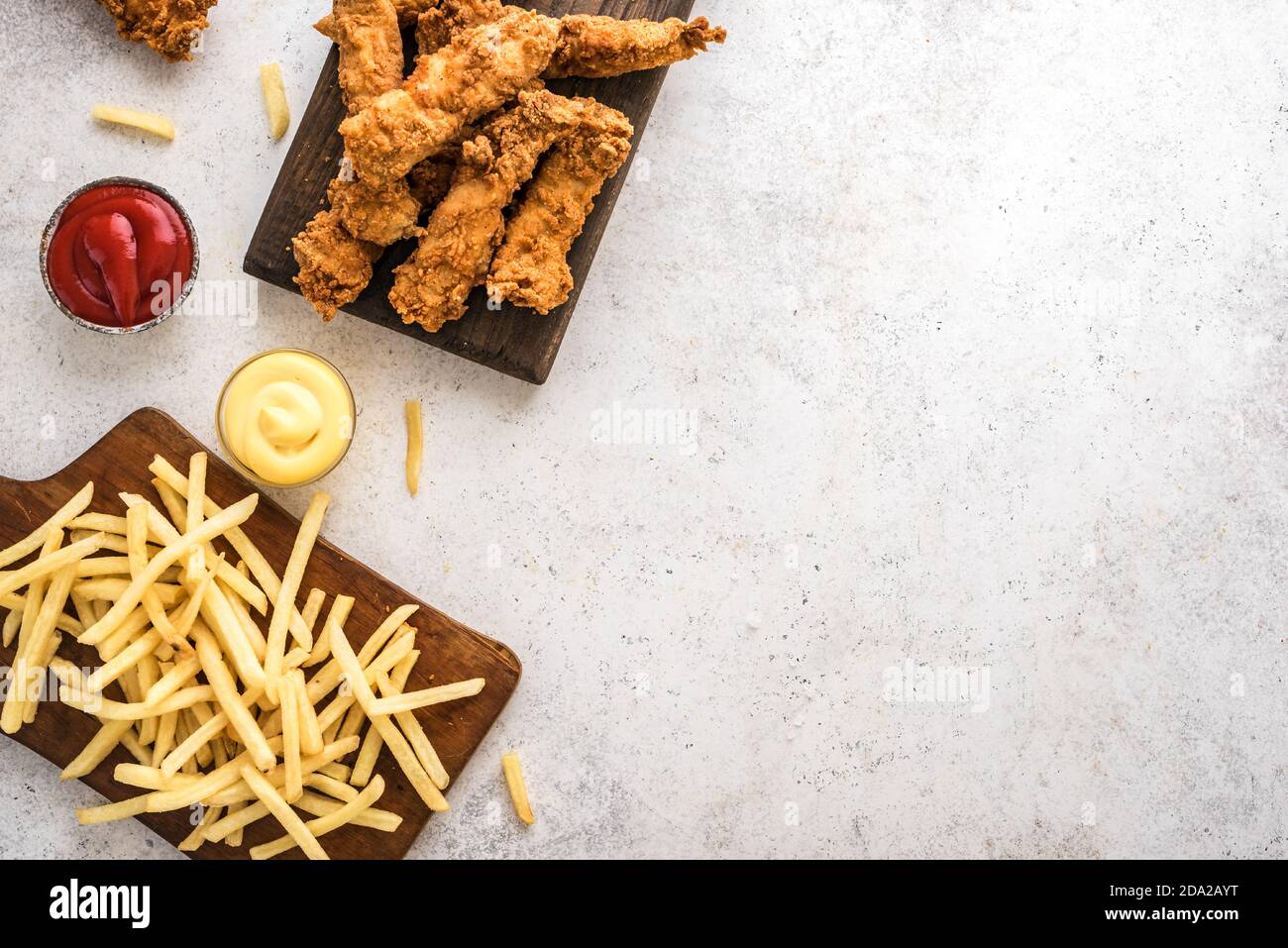 Poisson et frites. Filet de poisson frits et frites sur fond blanc avec sauces. Cuisine de rue britannique traditionnelle, vue sur le dessus, espace copie. Banque D'Images