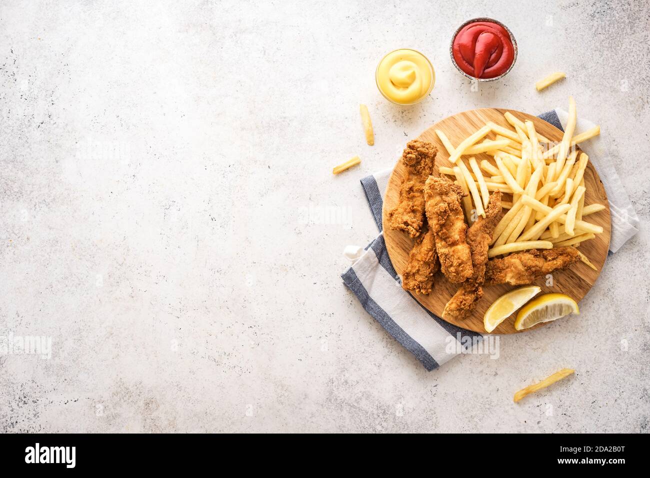 Poisson et frites. Filet de poisson frits et frites sur fond blanc avec sauces. Cuisine de rue britannique traditionnelle, vue sur le dessus, espace copie. Banque D'Images