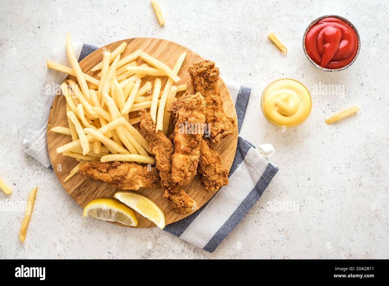 Poisson et frites. Filet de poisson frits et frites sur fond blanc avec sauces. Cuisine de rue britannique traditionnelle, vue sur le dessus, espace copie. Banque D'Images
