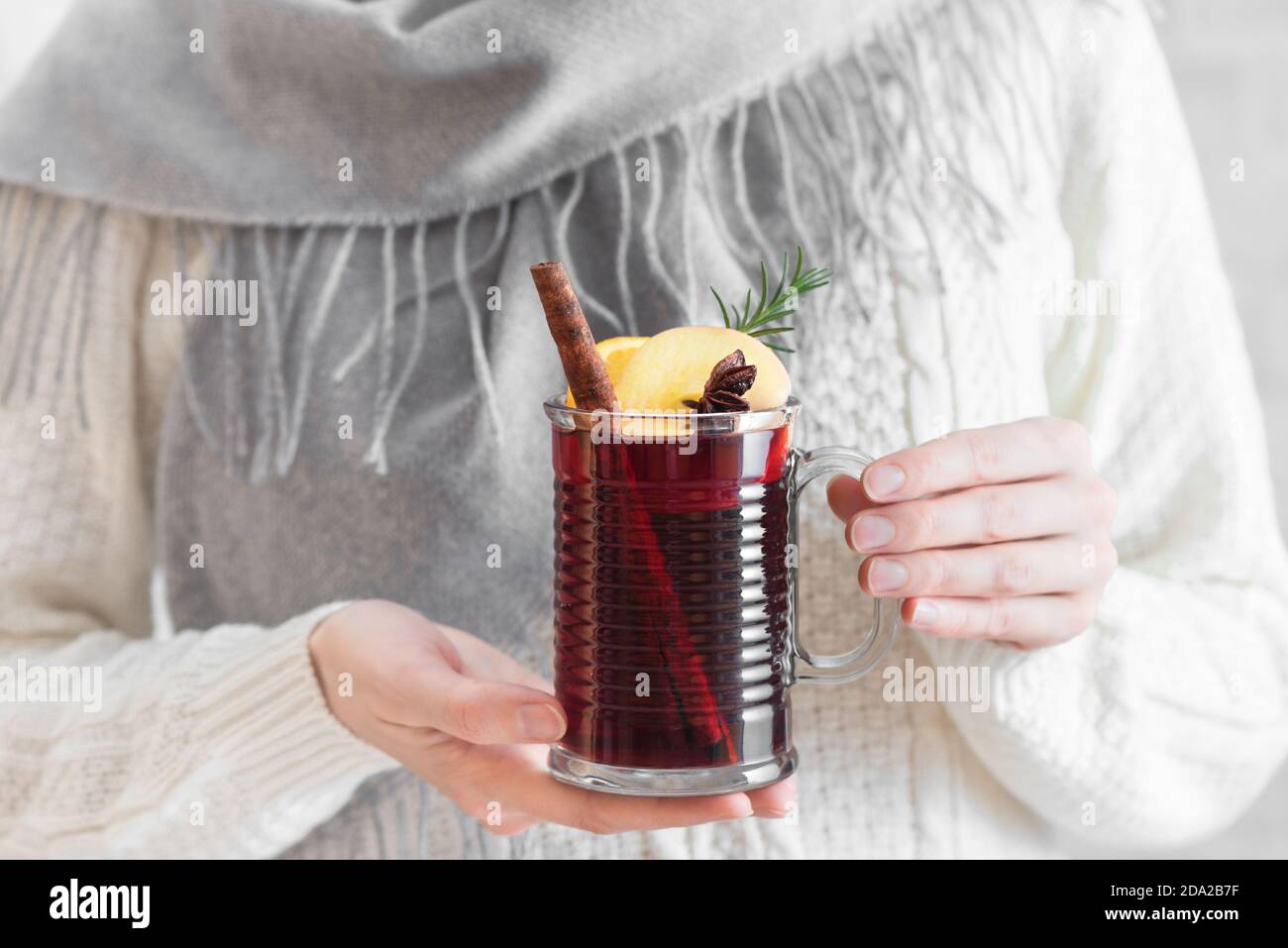 Femme tenant une tasse de vin chaud chaud. Mains de femmes avec une tasse de boisson chaude d'hiver de saison. Boisson de Noël aux fruits maison, vin rouge chaud épicé. Banque D'Images