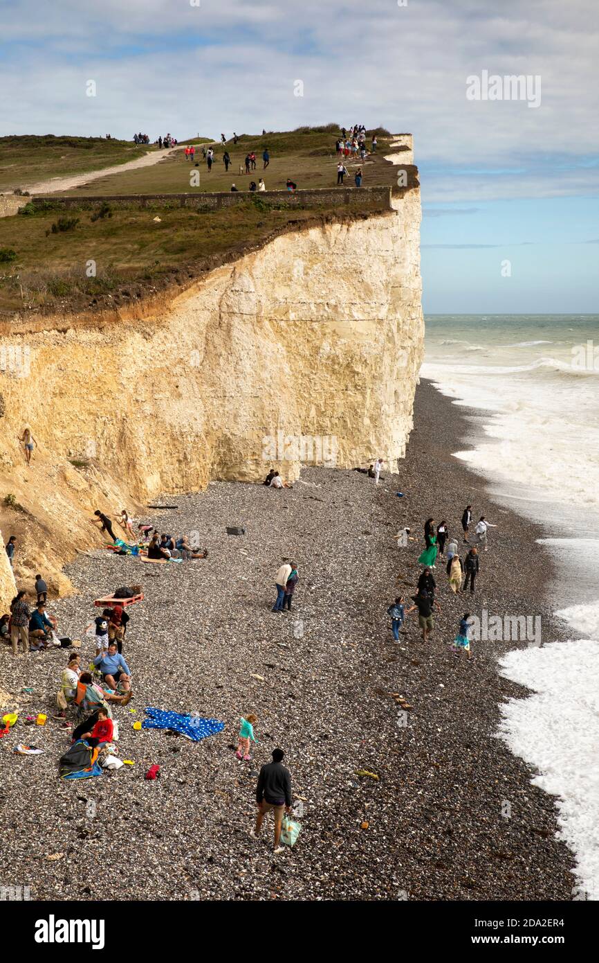 Royaume-Uni, Angleterre, East Sussex, Birling Gap, visiteurs sur la plage de galets sous les falaises de craie qui s'élèvent à Beachy Head Banque D'Images