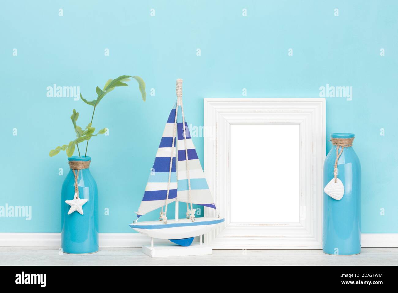 Modèle de maquette d'arrière-plan avec chic vintage ou shabby, cadre d'image vertical blanc rustique, bateau à voile en bois, vases décorés, un avec le fougères Banque D'Images