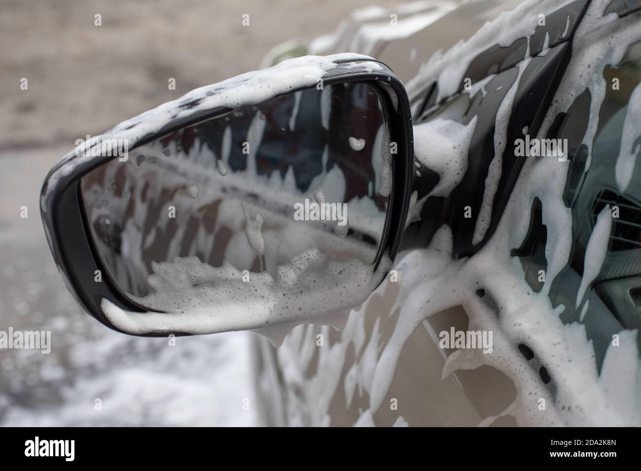 Miroir de voiture en mousse savonneuse lors d'un service de lavage de voiture. Auto-service nettoyage, photographie Banque D'Images