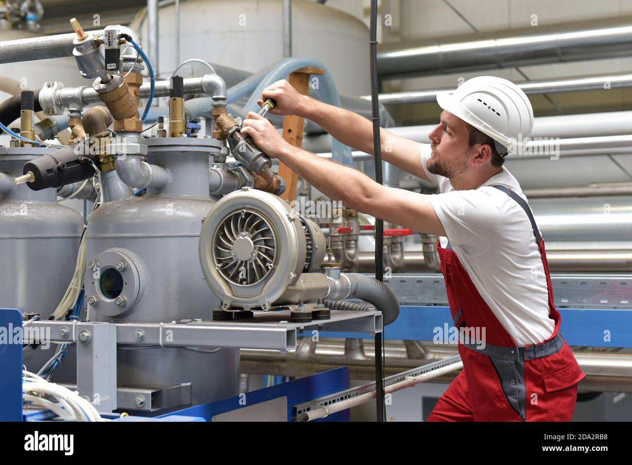 Réparation mécanique une machine dans une usine industrielle moderne - profession et d'équipe Banque D'Images