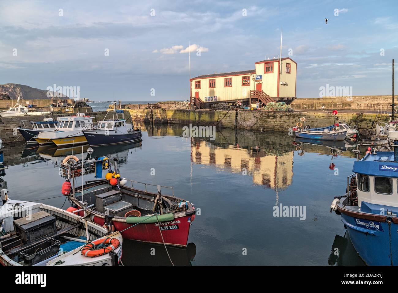 Des bateaux de pêche et une maison de sauvetage dans le port de St Abbs, un petit village de pêcheurs près de Coldingham dans le Berwickshire, en Écosse Banque D'Images