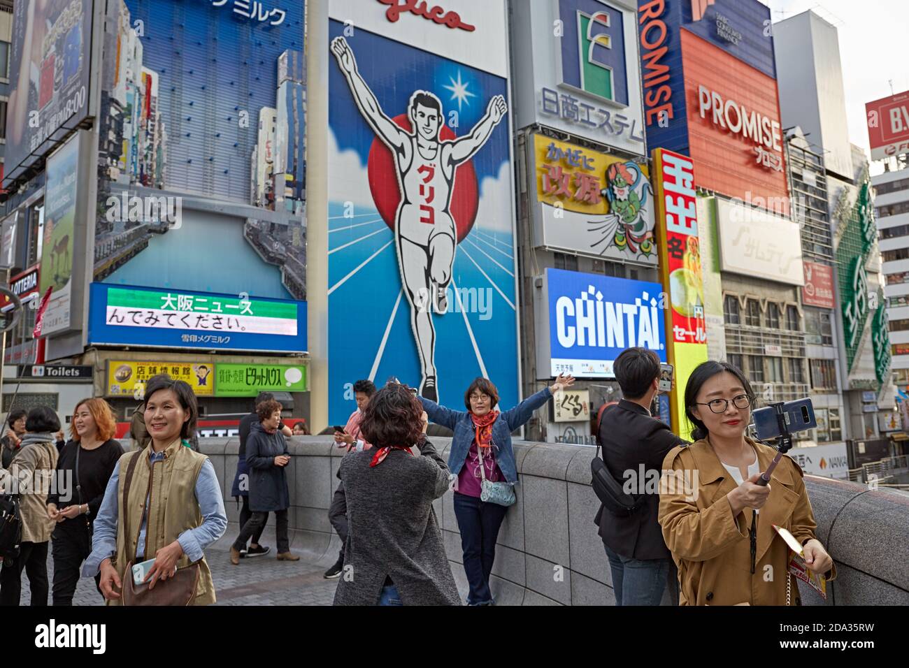 Osaka, Japon, avril 2018. Les gens qui font des selfies devant le signe lumineux de l'homme courant Glico à Dotombori, le plus célèbre point de repère du c Banque D'Images