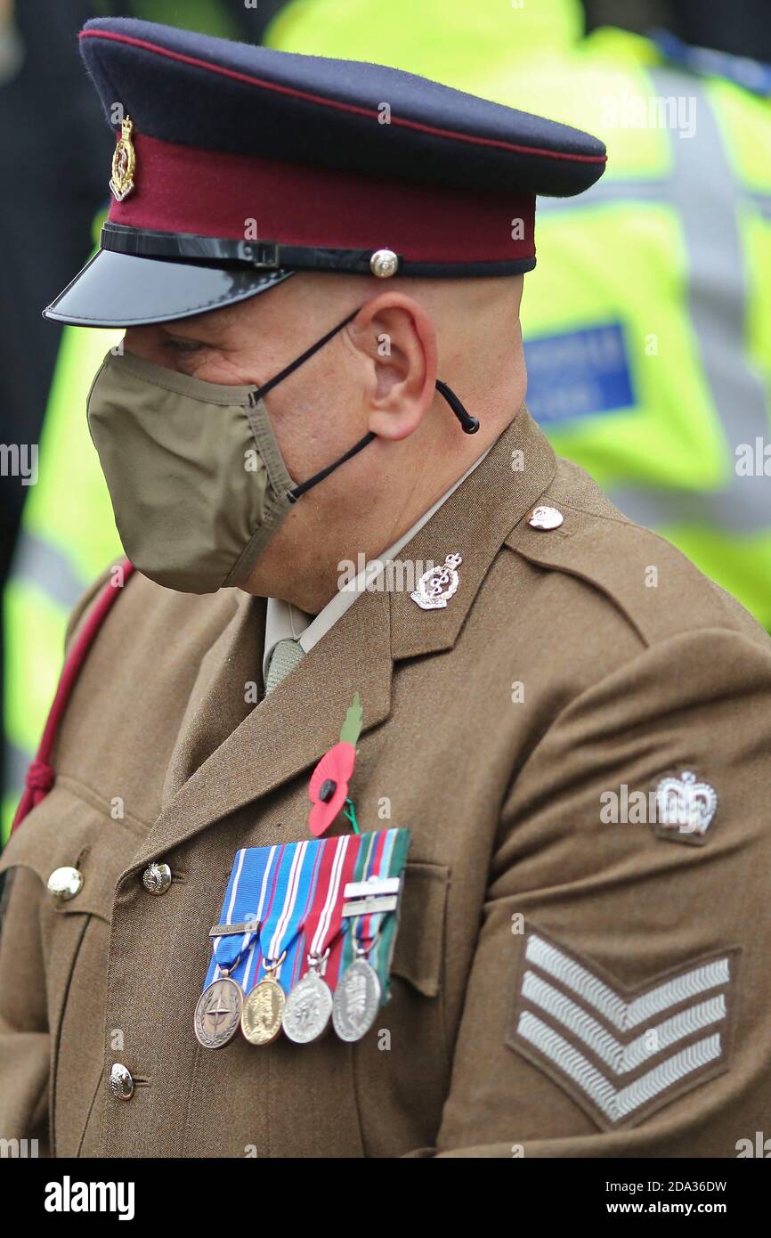 Commémoration du souvenir tenue au Cenotaph à Crickowell, Powys, pays de Galles du Sud, le 8 novembre 2020. Un officier de l'armée portant un masque attend Banque D'Images