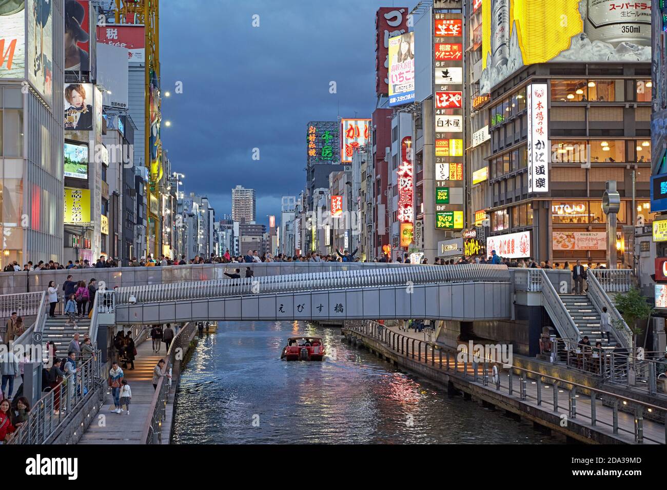 Osaka, Japon, avril 2018. Personnes traversant le pont Ebisu sur le canal Dontonbori au coucher du soleil. Banque D'Images