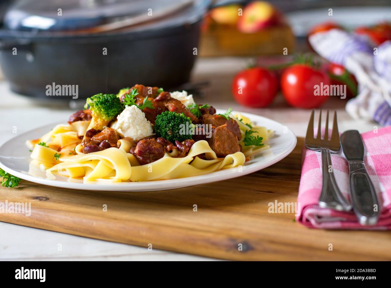 délicieux goulash de porc avec garniture à la crème aigre et pâtes sur une plaque Banque D'Images