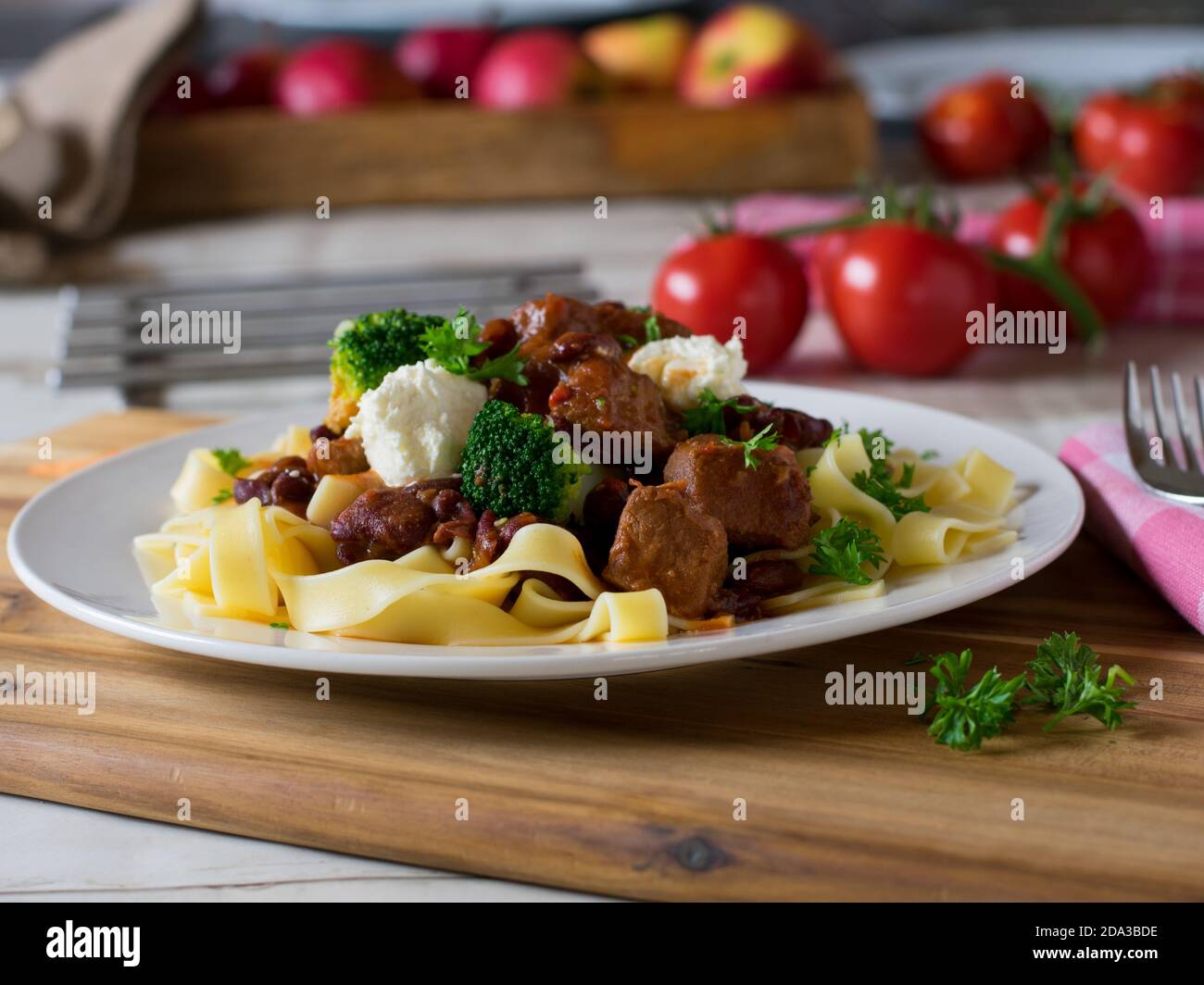 délicieux goulash de porc avec garniture à la crème aigre et pâtes sur une plaque Banque D'Images