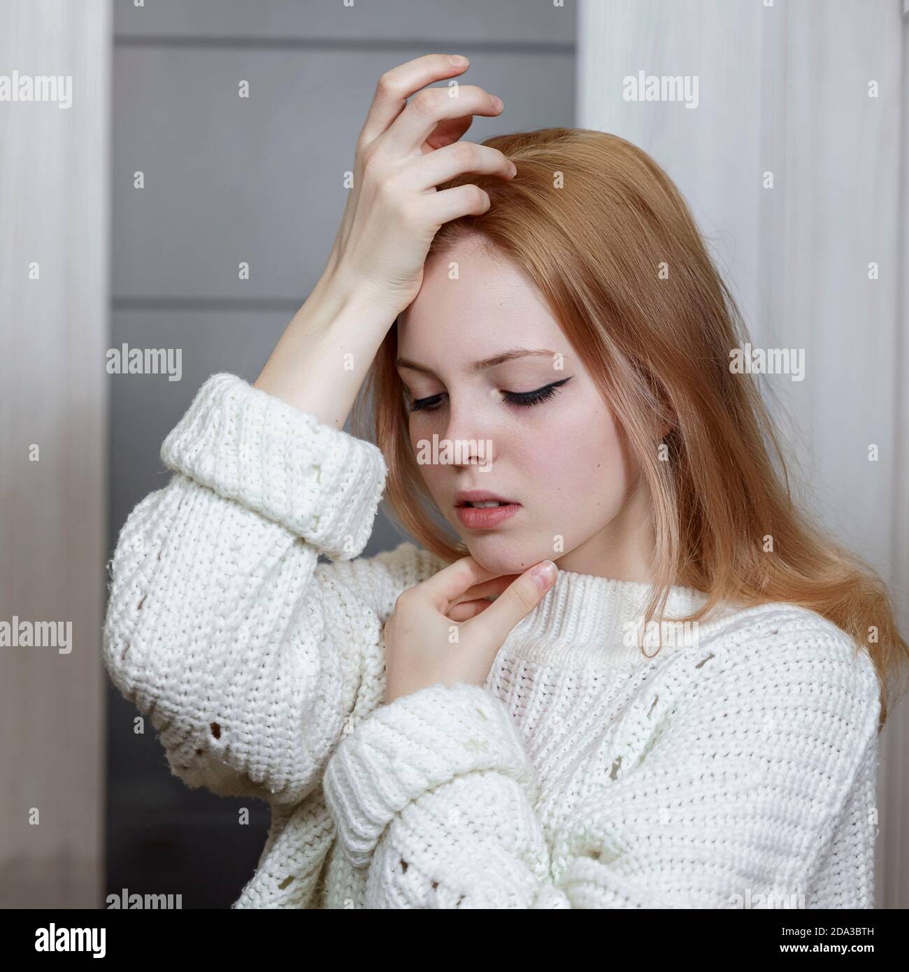 portrait d'une triste belle fille caucasienne de 16 ans dans un pull blanc tricoté Banque D'Images