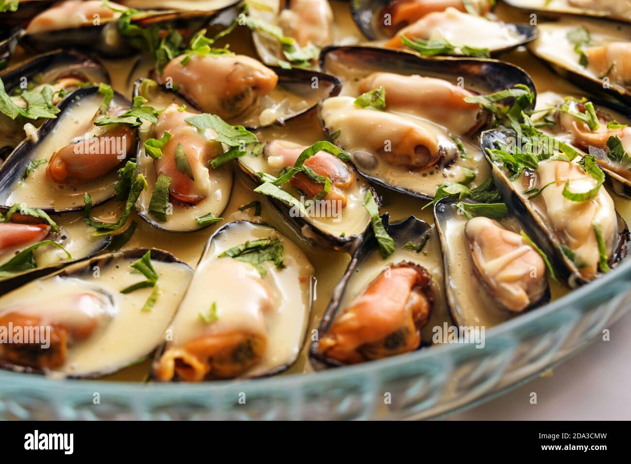 Moules bleues avec sauce à la crème de vin blanc sur une assiette de verre, gros plan, mise au point sélectionnée, champ étroit Banque D'Images