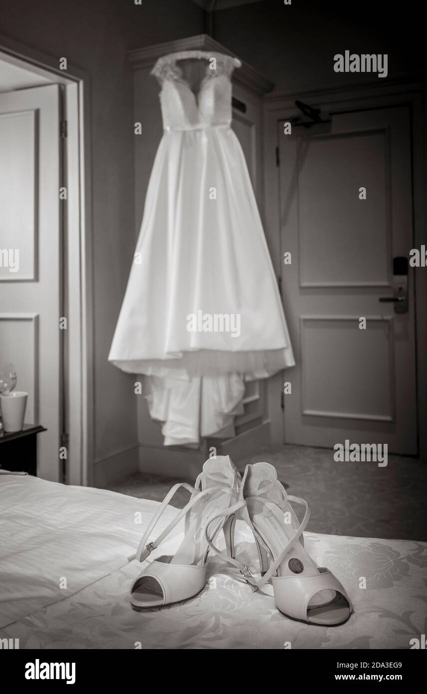 Robe de mariée accrochée à une garde-robe avec des chaussures au premier  plan Photo Stock - Alamy