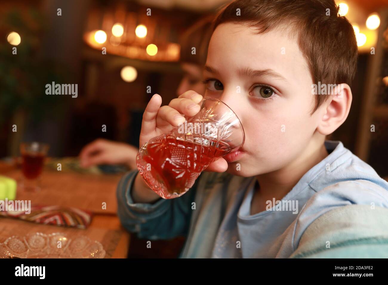 Garçon buvant du thé à l'hibiscus dans un restaurant Banque D'Images