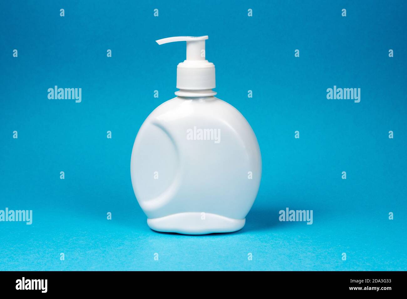 Bouteille blanche, distributeur de savon liquide, antiseptique sur fond bleu. Maquette, placer pour le texte. Banque D'Images