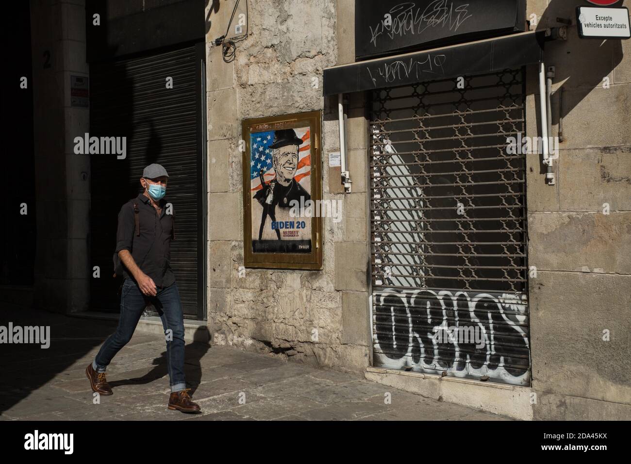 Barcelone, Espagne. 9 novembre 2020. Un homme portant un masque passe devant une œuvre de l'artiste espagnol TVBOY dans la rue de Barcelone, après la victoire du démocrate Joe Biden aux élections présidentielles américaines. Credit: Thiago PrudÃªNcio/SOPA Images/ZUMA Wire/Alay Live News Banque D'Images