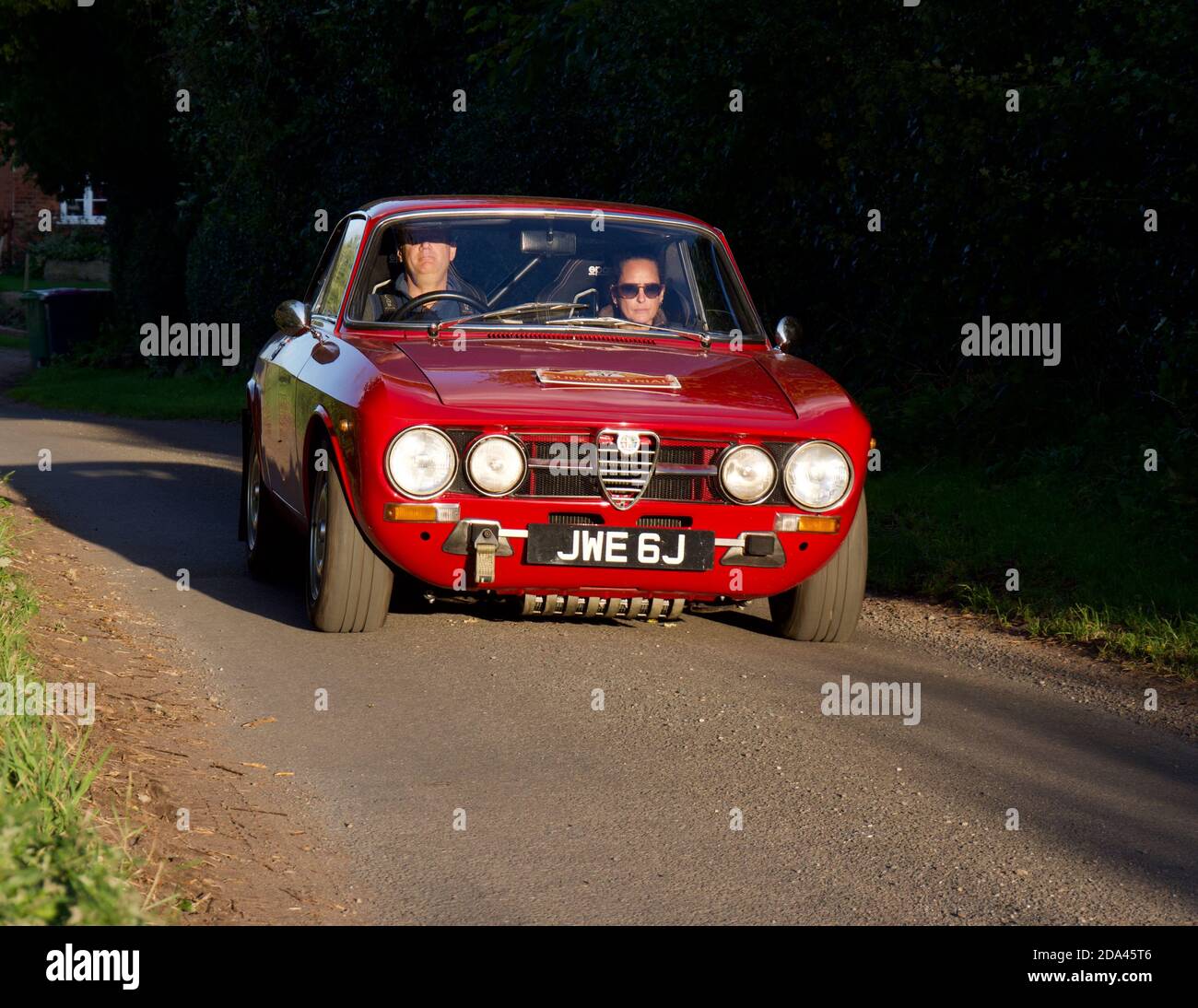 Rallye en voiture dans la lumière du soleil du soir dans un classique Alfa Roméo GTV Banque D'Images