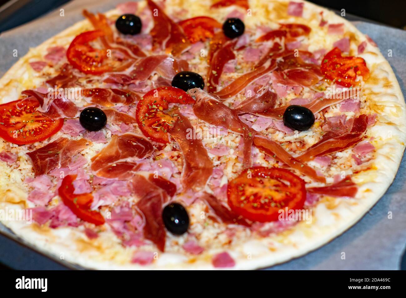 Pizza italienne avec jambon de tomate et olives prêtes à l'emploi servi cuisiné à la maison Banque D'Images