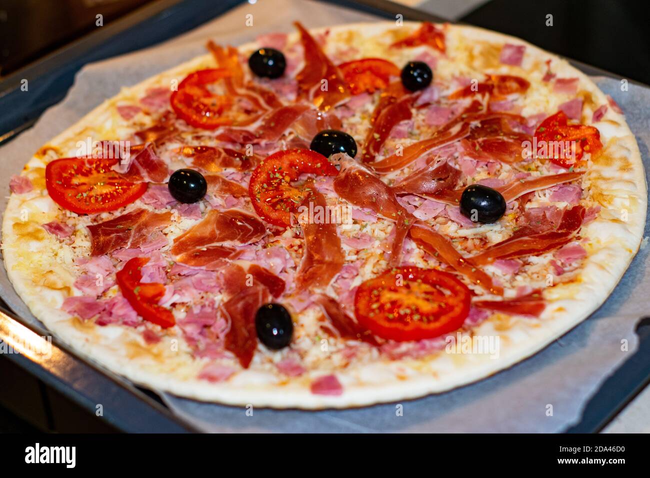 Pizza italienne avec jambon de tomate et olives prêtes à l'emploi servi cuisiné à la maison Banque D'Images