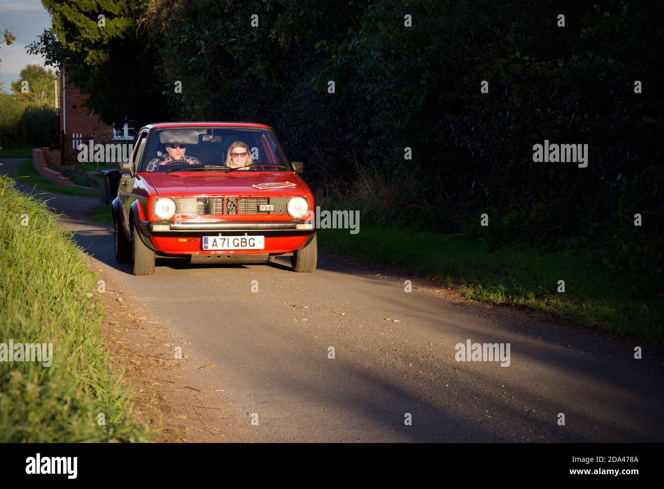 Rallye en route vers le soleil de la soirée dans un VW rouge Marque GolfGTI 1 Banque D'Images