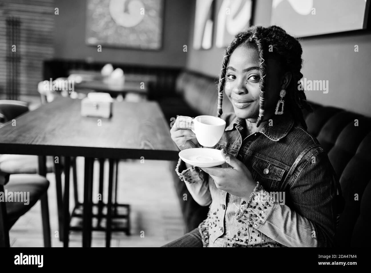 Belle femme afro-américaine avec des dreadlocks dans bleu élégant Jean  veste au café. Belle fraîche et tendance noir jeune fille boisson  d'intérieur café Photo Stock - Alamy